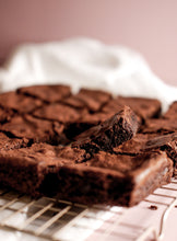 Load image into Gallery viewer, Vertical photo showing batch of Nick&amp;Fritz Gluten-free brownies on a cooling rack
